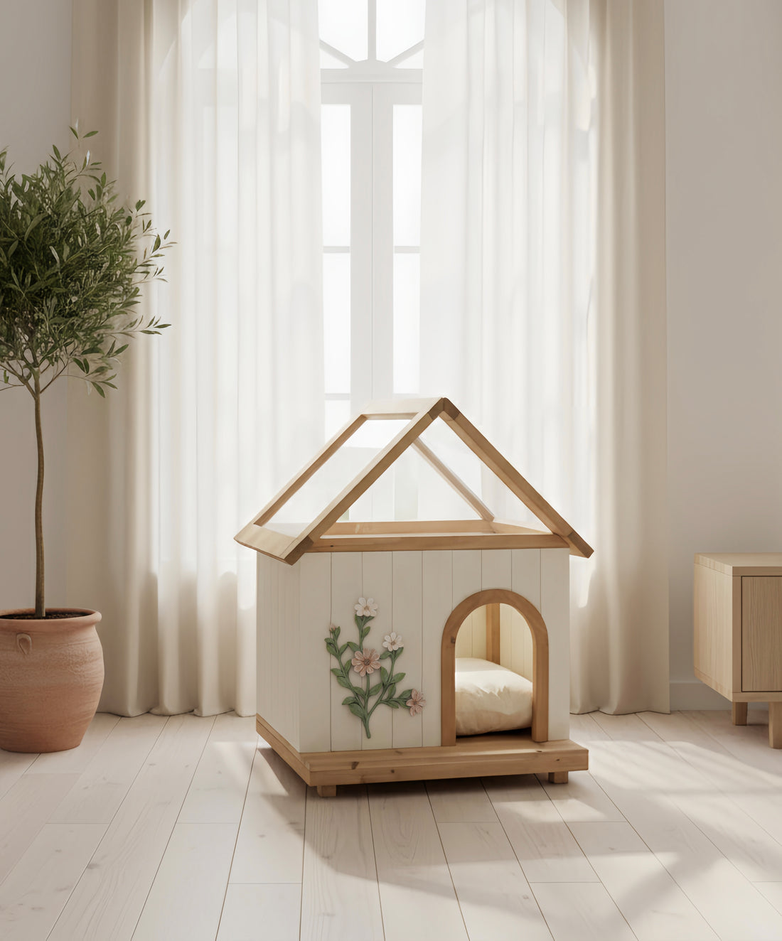 Wooden pet house with floral design on a light wooden floor with a plant and curtain in the background